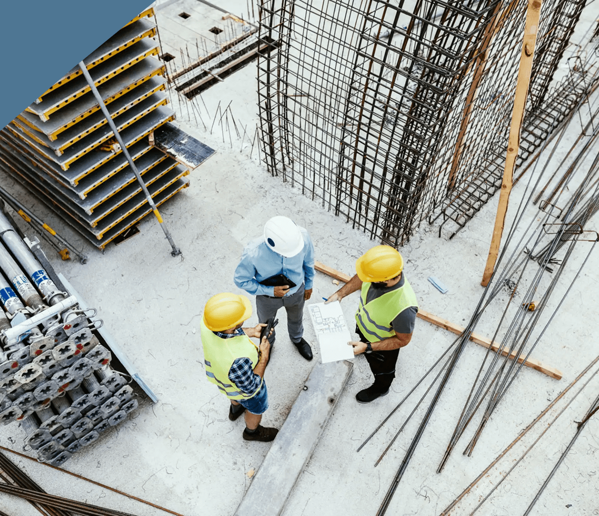 Workers pouring concrete during machine foundation construction at industrial site.